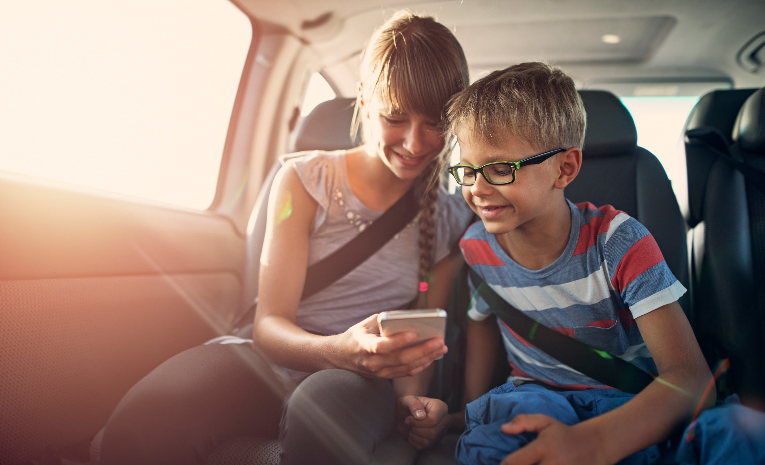 Siblings playing games via smartphone in car