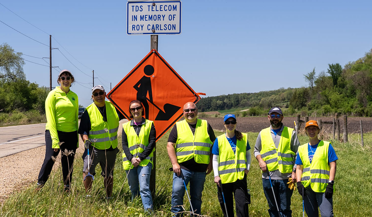 Seven people on the side of the road wearing yellow vests