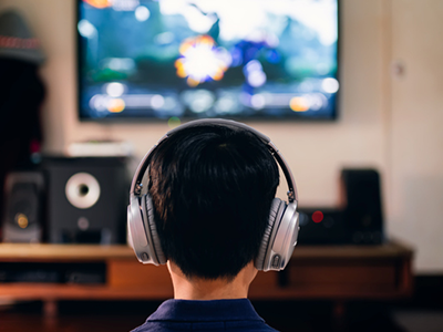 Strong Signal, Wherever You Play A young boy wearing headphones and playing a video game on his TV